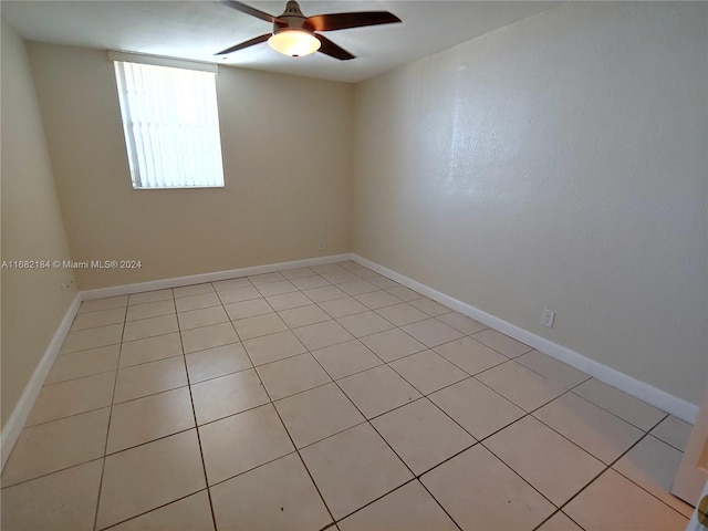 tiled spare room with ceiling fan