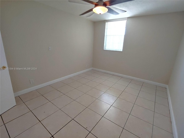 tiled spare room with ceiling fan