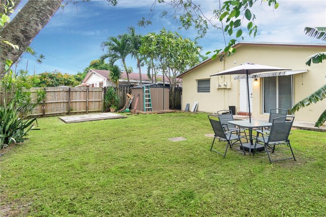 view of yard with a storage shed and a patio area