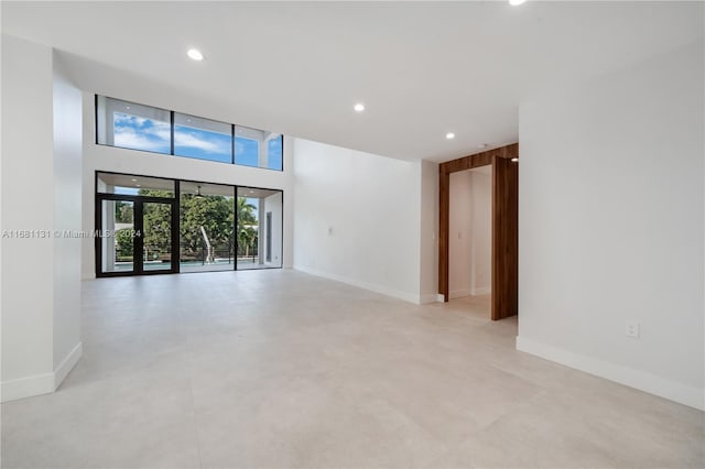 spare room with a high ceiling and french doors