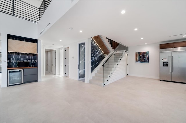 unfurnished living room with bar and beverage cooler