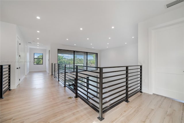 hall with light hardwood / wood-style flooring and plenty of natural light