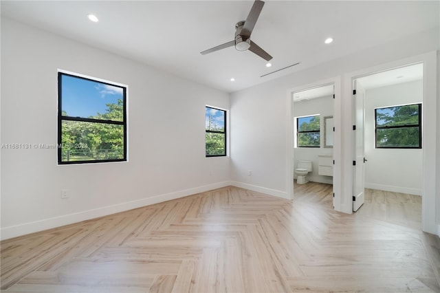 unfurnished bedroom featuring ensuite bathroom, ceiling fan, and light parquet floors