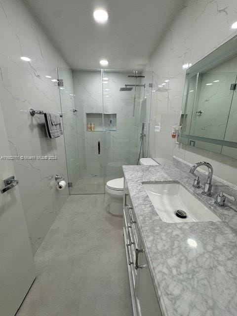 bathroom with toilet, a shower with shower door, and vanity