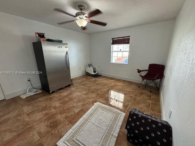 interior space with ceiling fan and stainless steel refrigerator