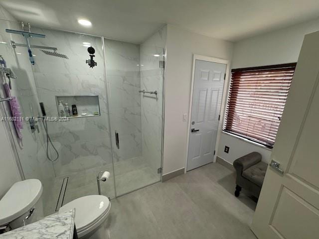 bathroom featuring vanity, a shower with shower door, and toilet