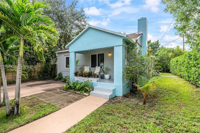 view of front of home with covered porch and a front yard