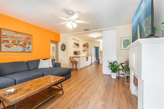 living room featuring ceiling fan and light hardwood / wood-style flooring