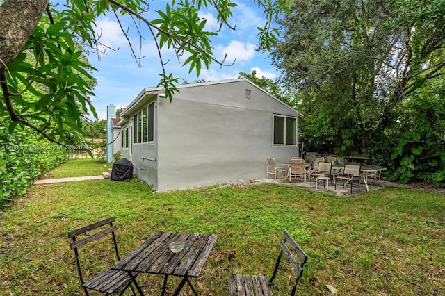 back of property featuring a patio and a lawn