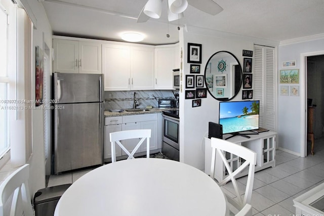 kitchen with ornamental molding, white cabinetry, and stainless steel appliances