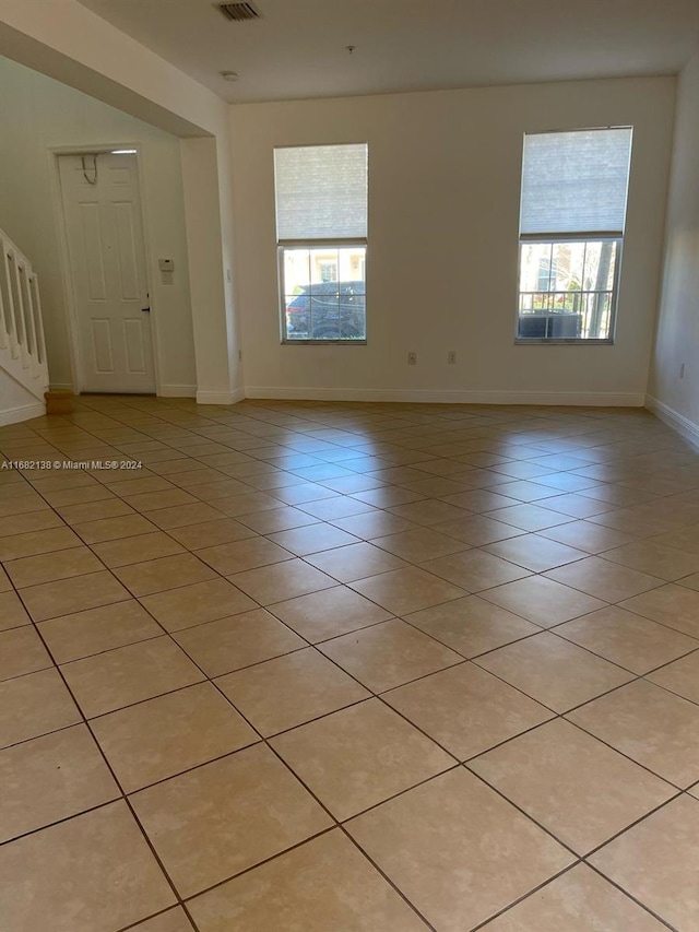 spare room featuring a wealth of natural light and light tile patterned flooring