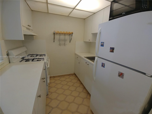 1305 W 53rd St Unit 410, Hialeah, FL 33012 - kitchen featuring white appliances, white cabinetry, light countertops, and under cabinet range hood