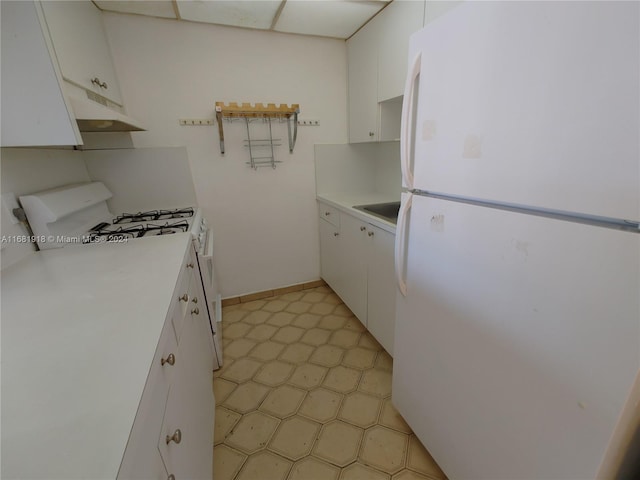 kitchen with sink, white cabinets, and white appliances