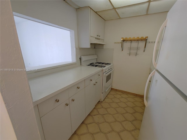 kitchen featuring white cabinetry, a paneled ceiling, and white appliances