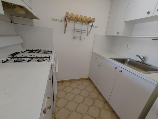1305 W 53rd St Unit 410, Hialeah, FL 33012 - kitchen featuring white gas range oven, open shelves, under cabinet range hood, and white cabinetry