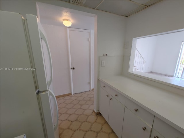 kitchen with white cabinets and white fridge