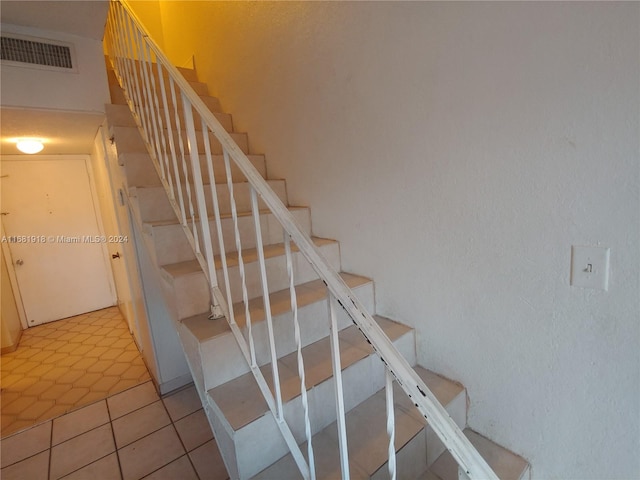 staircase with tile patterned floors