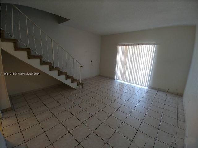 1305 W 53rd St Unit 410, Hialeah, FL 33012 - unfurnished living room featuring stairway and light tile patterned flooring