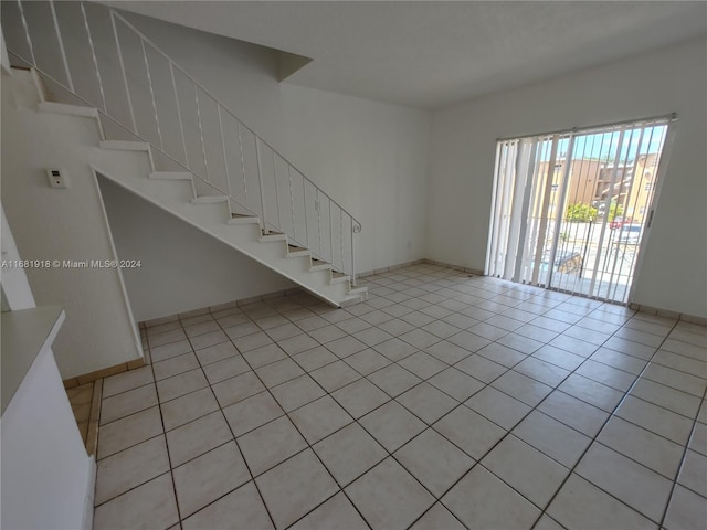1305 W 53rd St Unit 410, Hialeah, FL 33012 - unfurnished living room with stairs and light tile patterned flooring