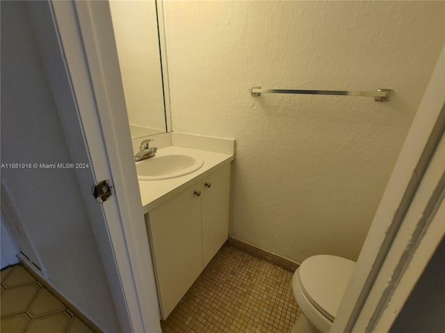 bathroom featuring vanity, toilet, and tile patterned flooring