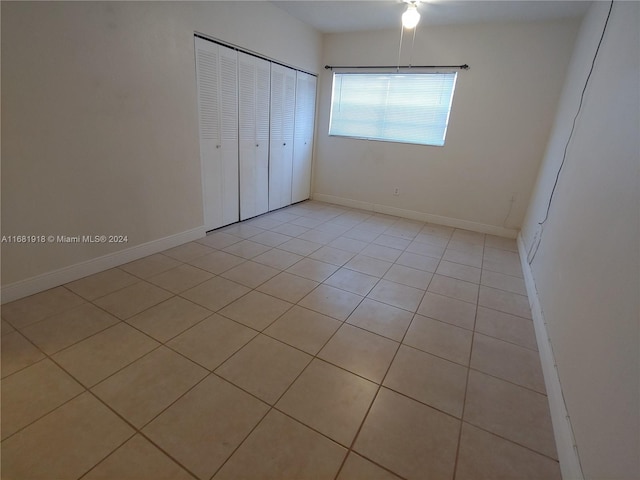 unfurnished bedroom with light tile patterned flooring and a closet