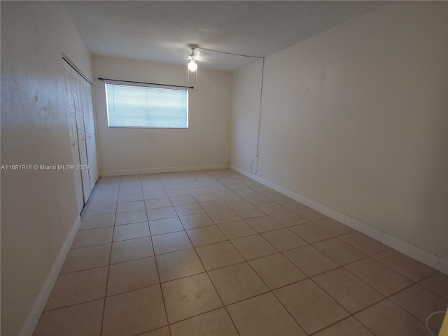 empty room with light tile patterned floors and ceiling fan