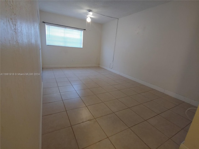 tiled spare room with ceiling fan