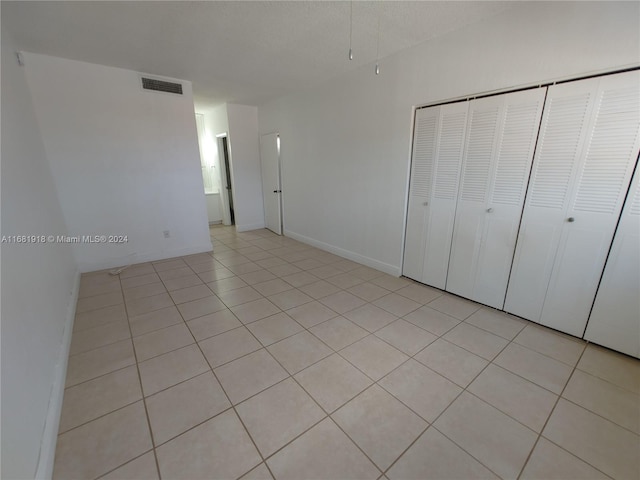 unfurnished bedroom featuring a closet and light tile patterned flooring