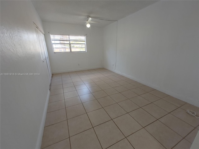 tiled spare room with ceiling fan