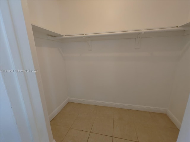 walk in closet with light tile patterned floors