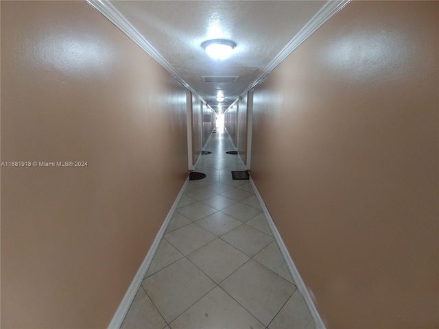 corridor featuring ornamental molding and light tile patterned floors