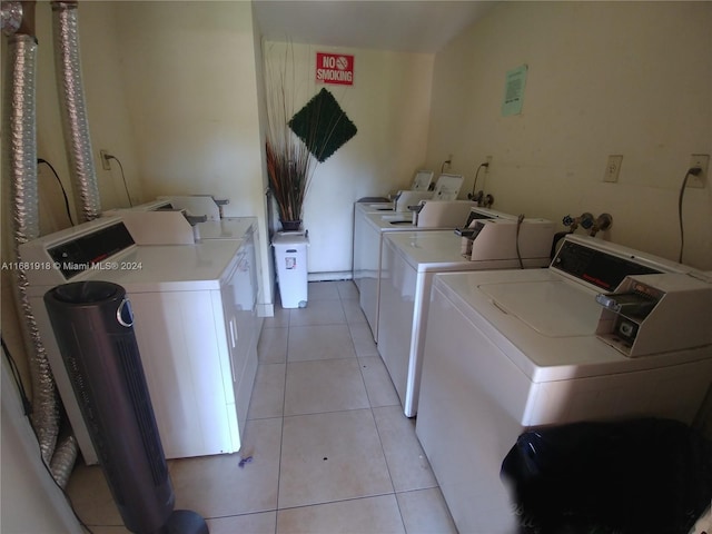 clothes washing area featuring separate washer and dryer and light tile patterned floors