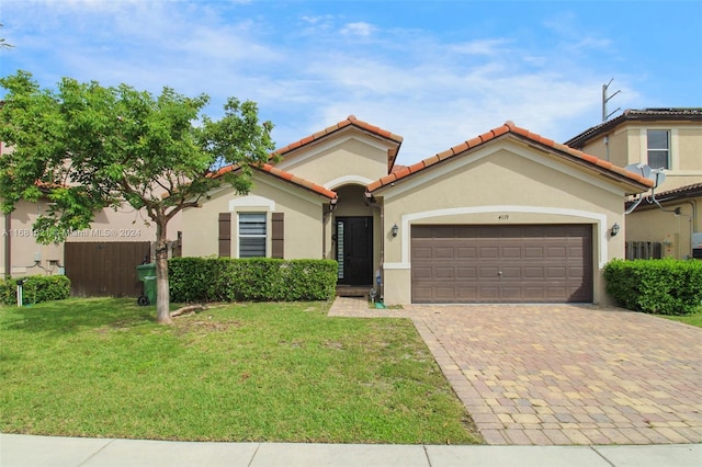 mediterranean / spanish house with a front yard and a garage