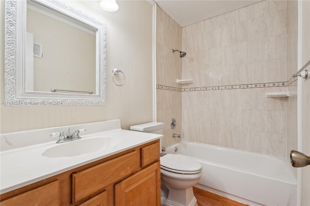 full bathroom with vanity, toilet, hardwood / wood-style flooring, and tiled shower / bath combo