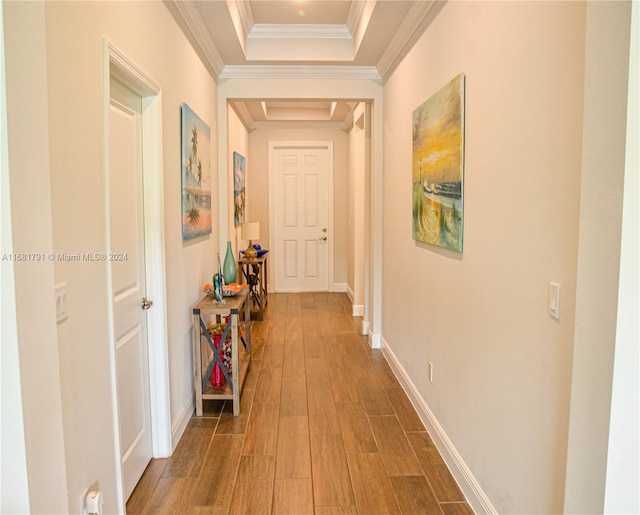 hallway featuring dark wood-type flooring, crown molding, and a tray ceiling