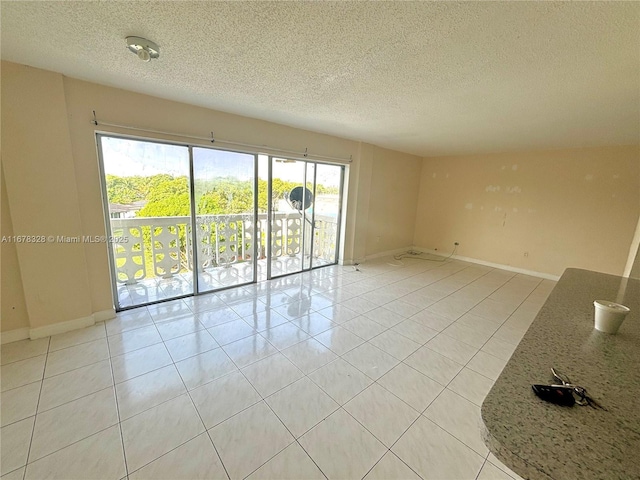 empty room featuring light tile patterned floors and a textured ceiling