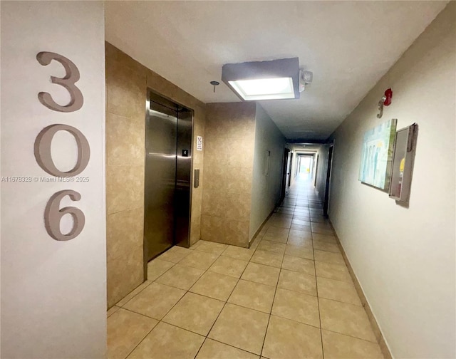 hallway featuring light tile patterned floors and elevator