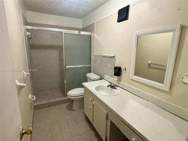 bathroom featuring walk in shower, vanity, toilet, and a textured ceiling