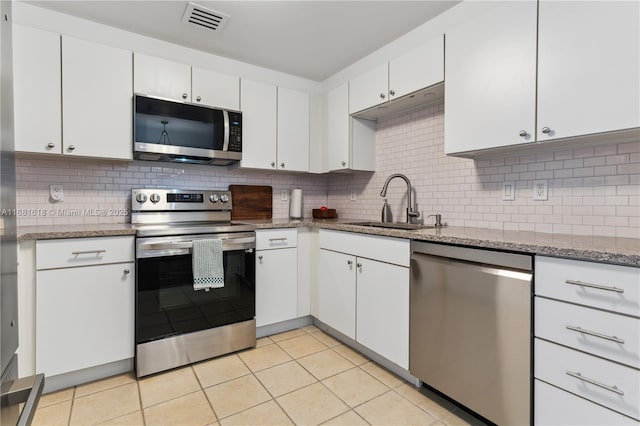 kitchen with stainless steel appliances, white cabinets, a sink, and visible vents