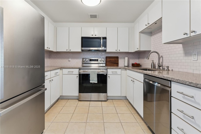 kitchen featuring light tile patterned floors, visible vents, appliances with stainless steel finishes, white cabinetry, and a sink