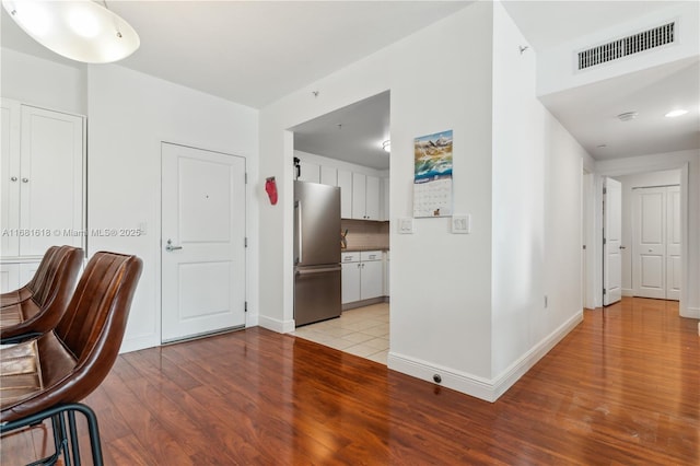 office area featuring light wood-style flooring, visible vents, and baseboards