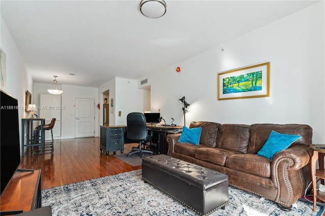 living area with visible vents and wood finished floors