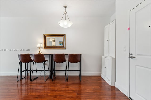 dining area featuring baseboards and dark wood finished floors