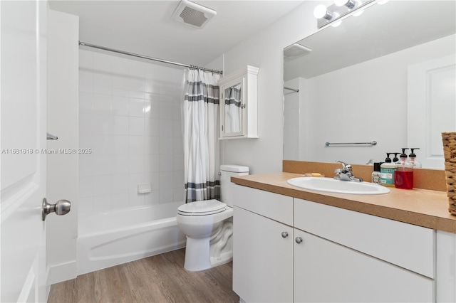 bathroom featuring visible vents, toilet, shower / tub combo, vanity, and wood finished floors