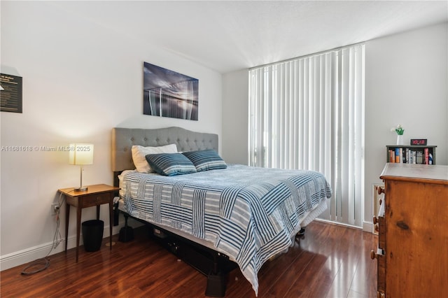 bedroom featuring baseboards and dark wood-style flooring