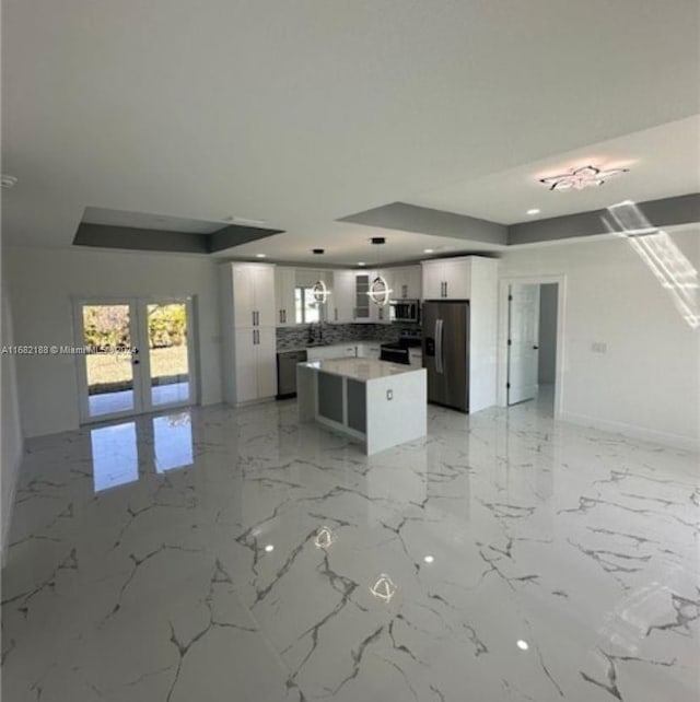 kitchen with french doors, appliances with stainless steel finishes, pendant lighting, and white cabinets