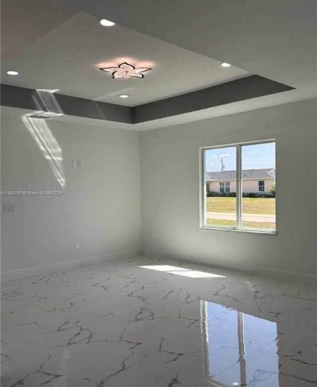 spare room featuring a raised ceiling