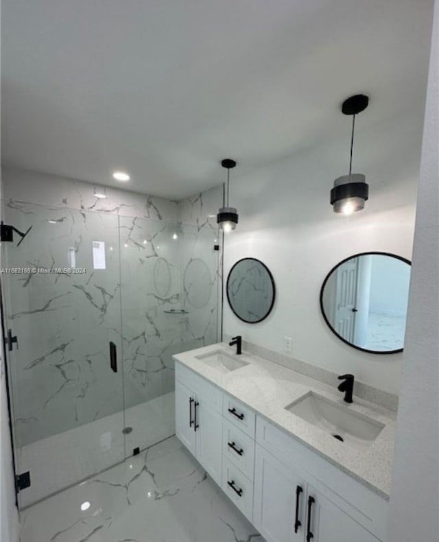 bathroom featuring a shower with door and vanity