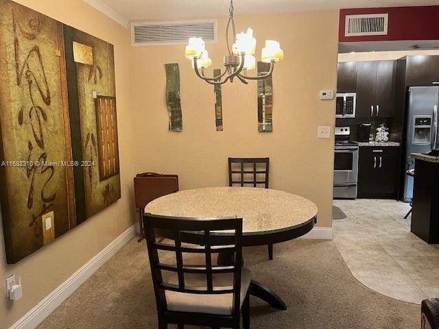 dining area featuring light tile patterned floors, ornamental molding, and an inviting chandelier