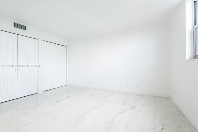 unfurnished bedroom with two closets